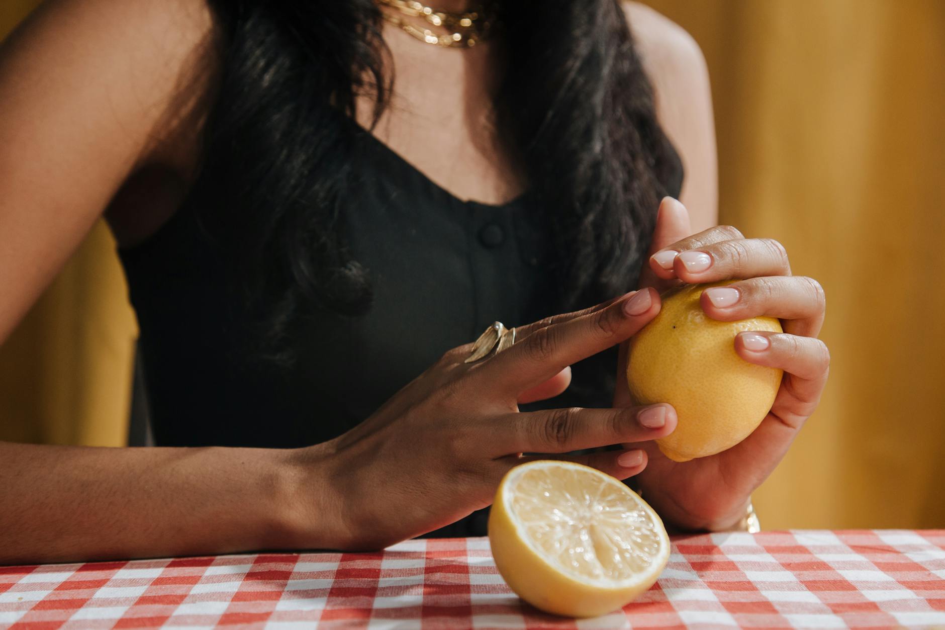 Close-up hands holding a sleek blue vibrator against a purple background