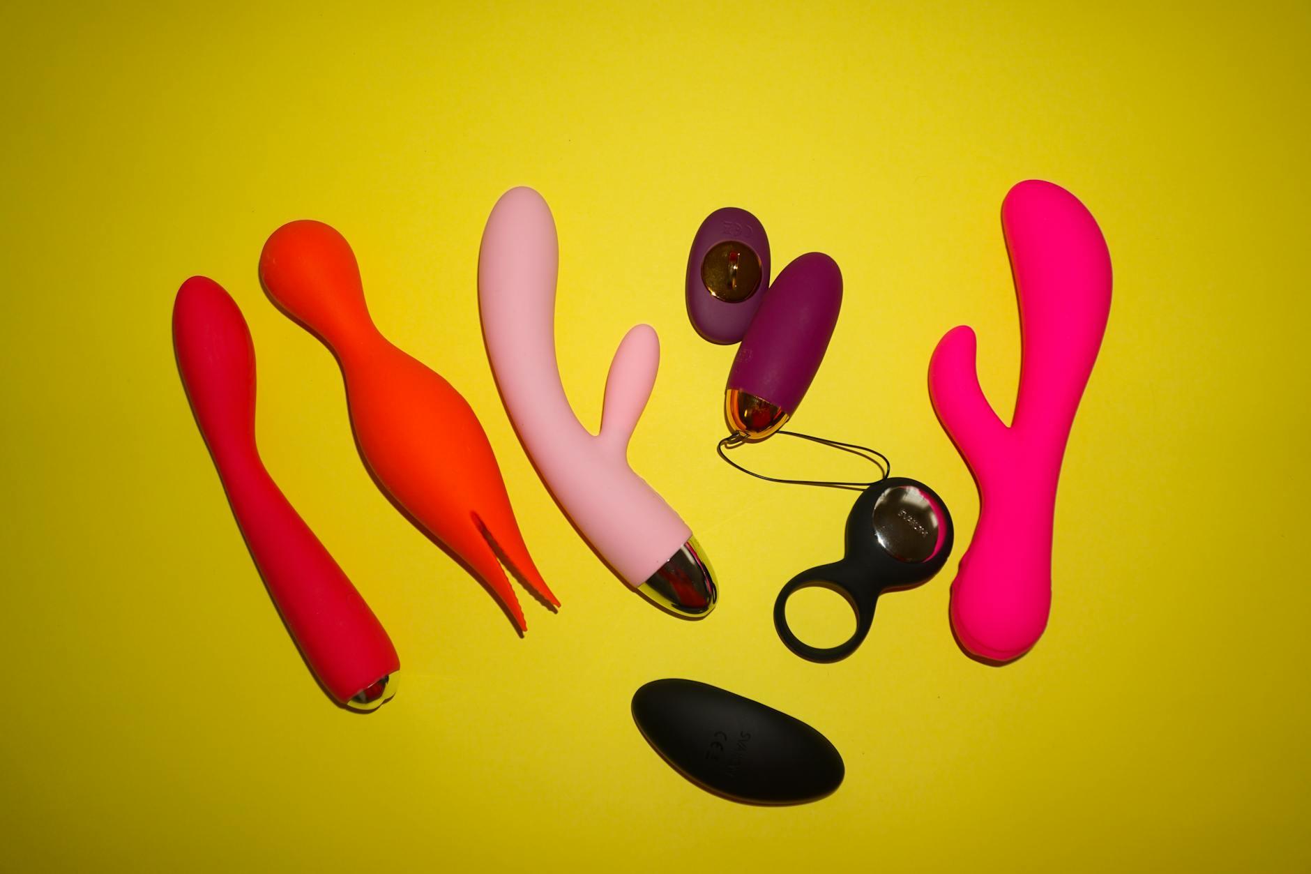 Hand holding a silicone vibrator against a solid purple background, promoting intentional self-pleasure